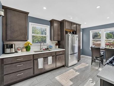 Modern kitchen with dark cabinets and gray walls.