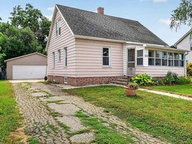 Cozy suburban house with a small front porch and detached garage.