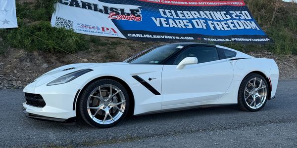 White sports car parked near a banner