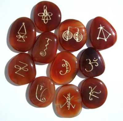 Red stones engraved with unique golden symbols arranged in a cluster.