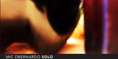 Blurred close-up of a hand and a glass with warm lighting.