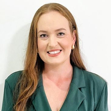 Dee Dalton headshot smiling in green jacket