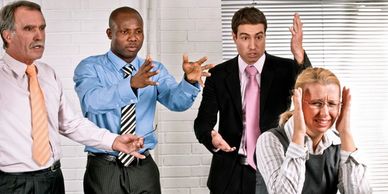 Three male coworkers fussing at a female coworker.