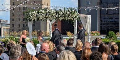 A wedding ceremony taking place on a rooftop with guests seated.