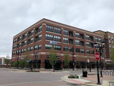 Exterior view of The Austin Coralville, a multi-story brick building with retail spaces.