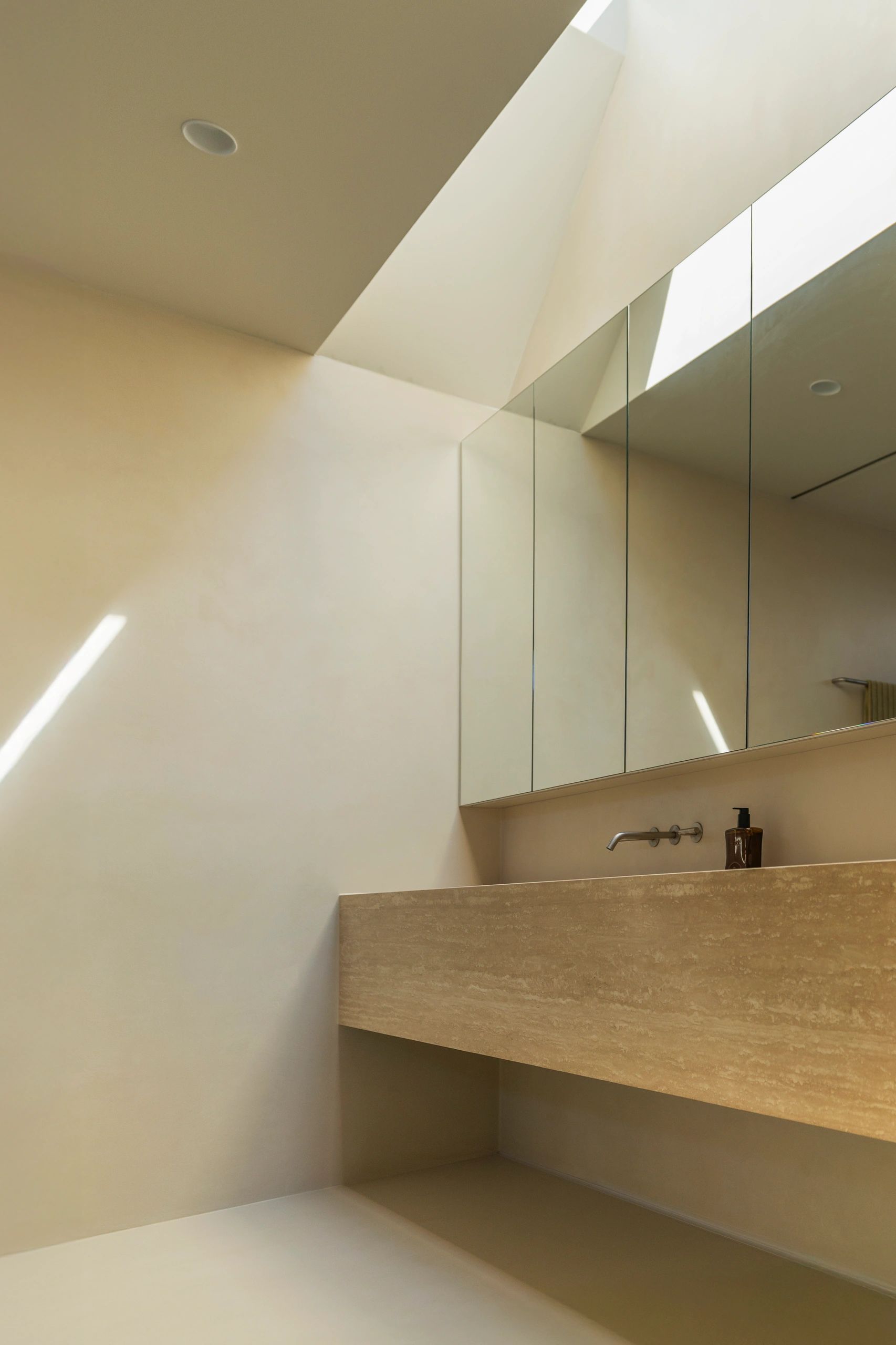 Minimalist bathroom with beige tones and natural light.