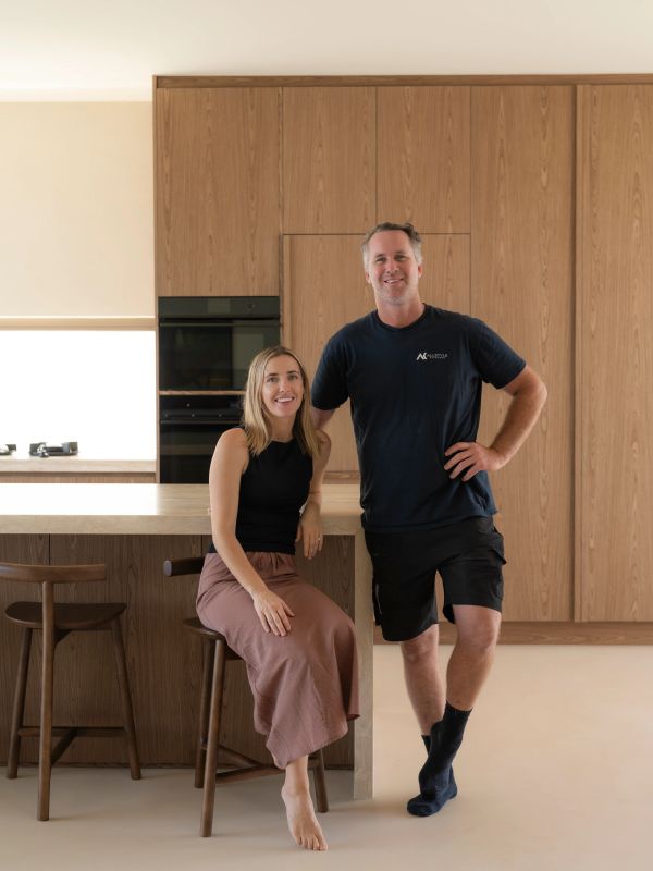 Couple posing in modern wooden kitchen.