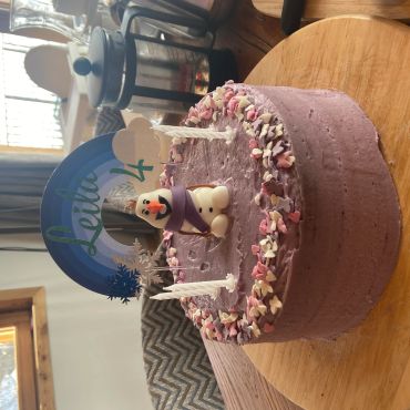 Purple birthday cake with Olaf figure and candles.