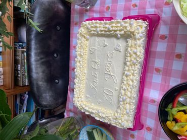 Celebratory cake for 30 years with decorative icing on a pink tablecloth.