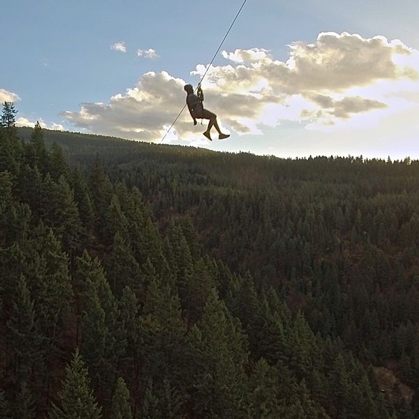 Silhouette of zip liner in the sky