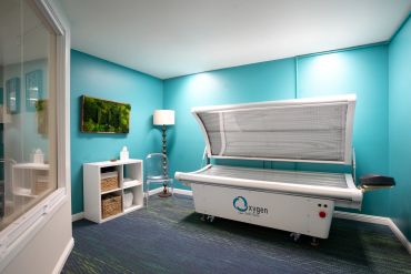 A modern hyperbaric oxygen therapy chamber in a bright treatment room.