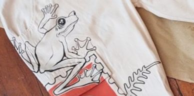 White pants with a detailed frog and leaf design on the leg.