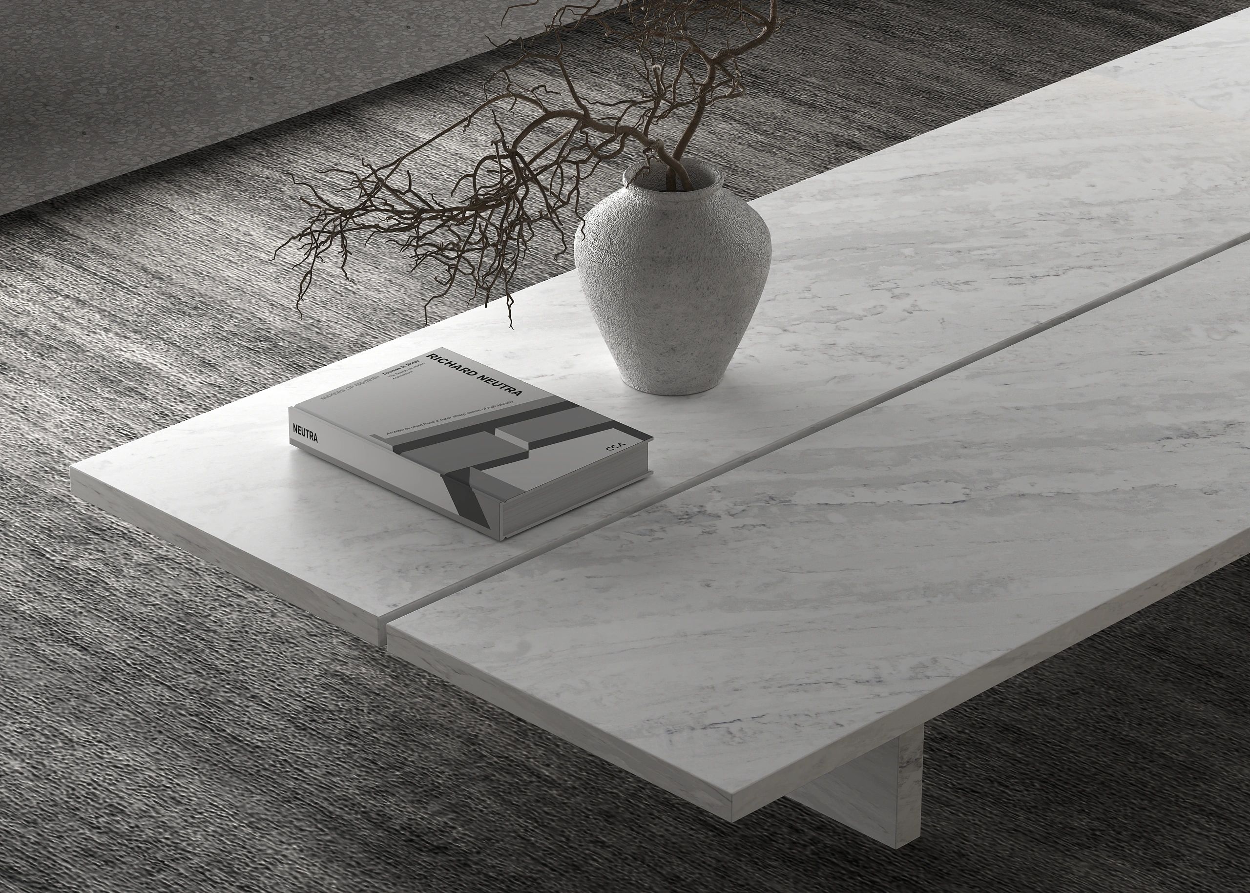 Minimalistic gray vase with branches and a Richard Neutra book on a marble table.