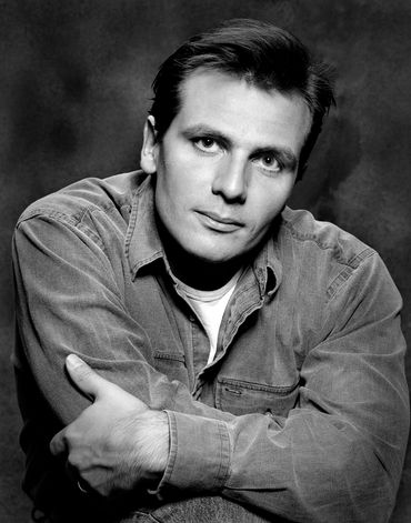 studio headshot of male actor in black and white