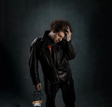 Young man wearing a leather jacket standing in a studio