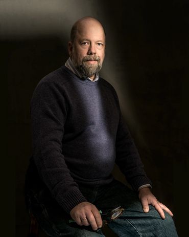 portrait of a bald man with dramatic light in a studio