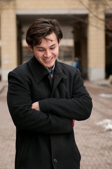 branding portrait of a young man in a black coat outside 