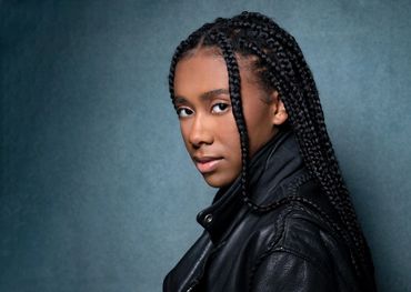 headshot of a young black woman with braids shot in a studio