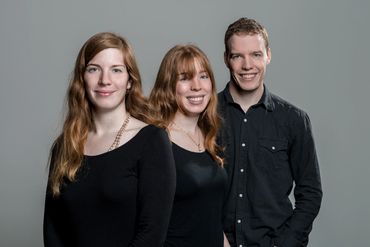 portrait of three young adults in a studio setting
