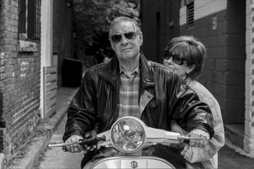 branding portrait of a man on a scooter with a woman on the back seat in black and white