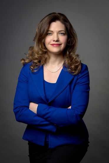 corporate portrait of a business woman on a dark grey background in a studio setting