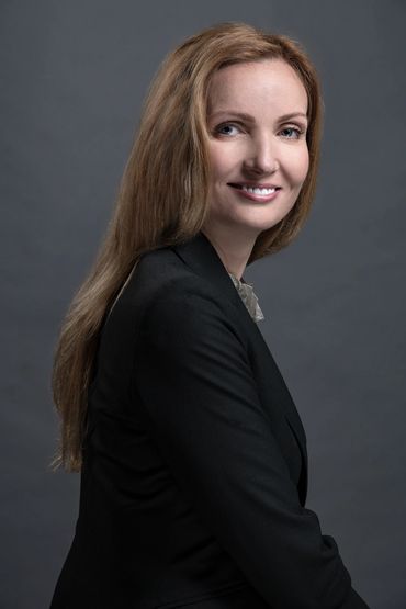 Studio headshot of a woman in front of a grey wall