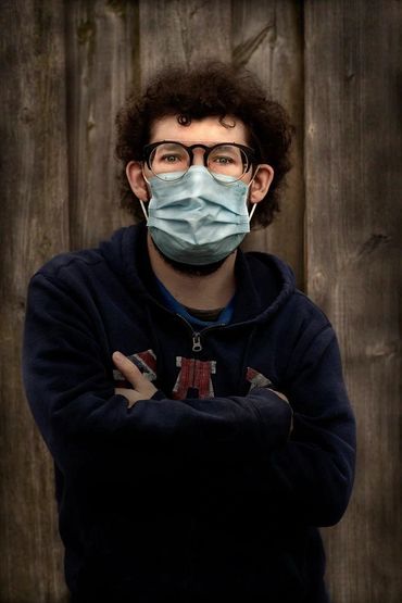 portrait of a young man wearing a medical mask during the COVID 19 pandemic outside