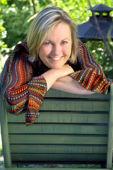 branding headshot of a smiling woman leaning on the back of a chair