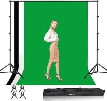 Model posing in front of a green screen backdrop with photography equipment.