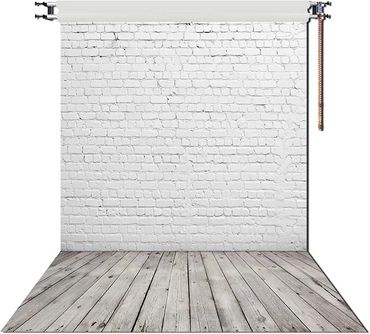 Photography backdrop with white brick wall and wooden floor.