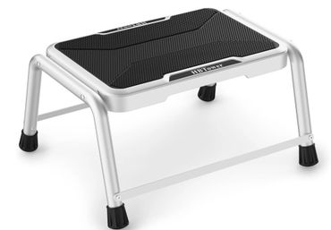 A small, sturdy aluminum step stool with a black non-slip top surface.