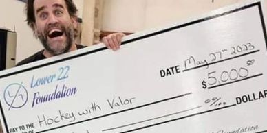 Adam holding an oversized check for $5,000.