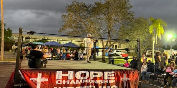 Outdoor wrestling event with an audience.