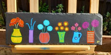 Long slate piece with 6 small vases of flowers