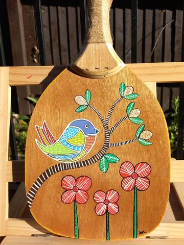 Solid wooden bat painted with a colourful abstract bird on a branch