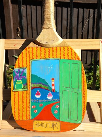 Solid wooden bat painted with a seaside scene looking through a door