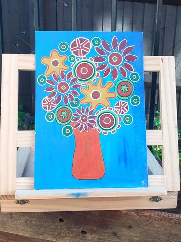 Abstract flowers in an orange vase with a blue background