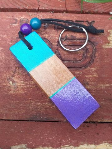 Small wooden block, decorated with a hole drilled through the top with a keyring attached