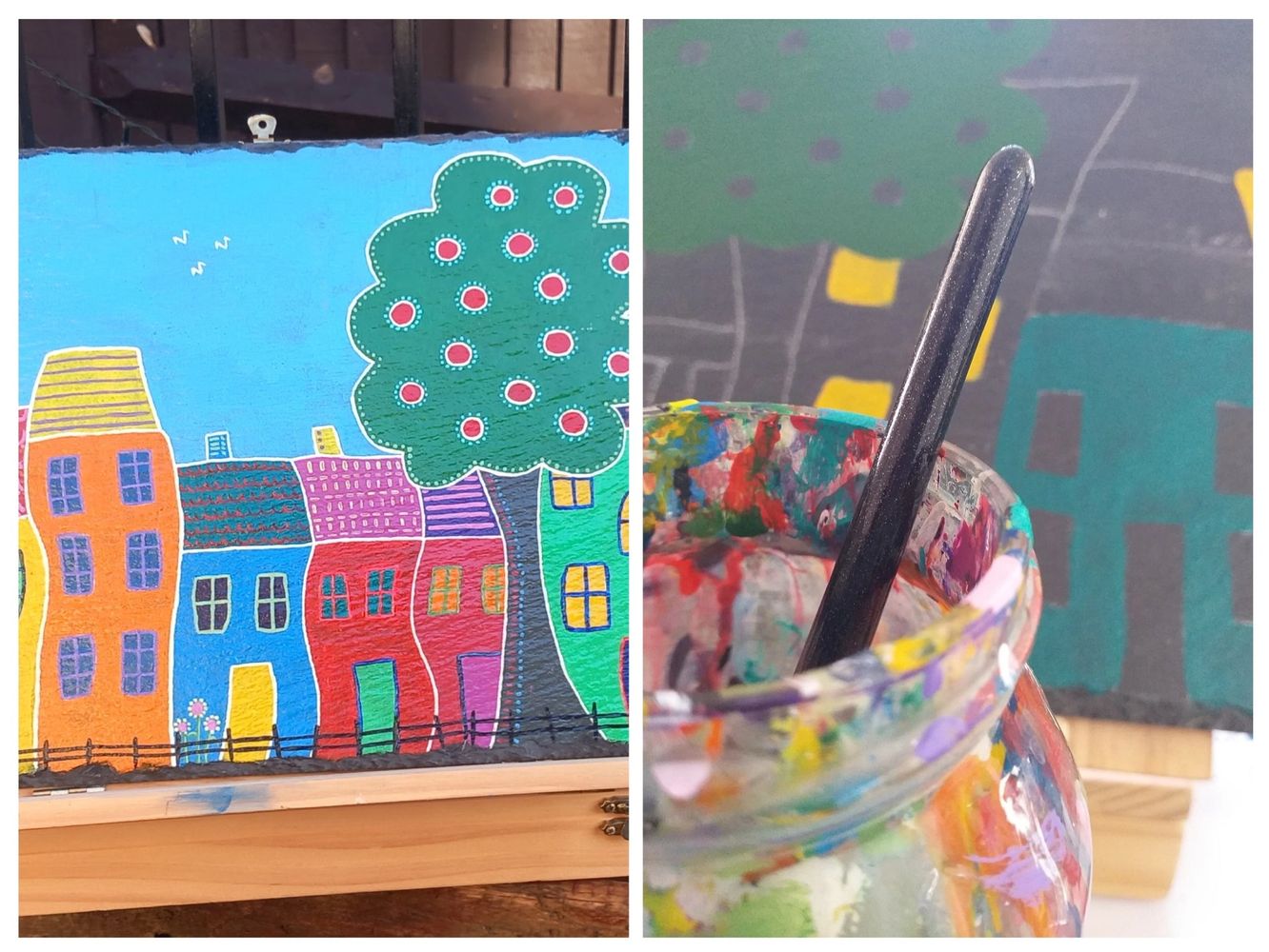 A piece of slate painted with a colourful abstract street scene & a water jar & brush.
