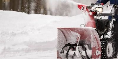 Snowblower clearing snow on a driveway.