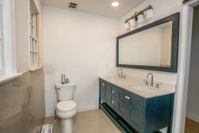 Modern bathroom with double sinks and a toilet.