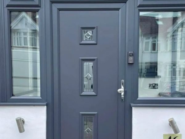 Modern gray front door with decorative glass panels and house number 46.