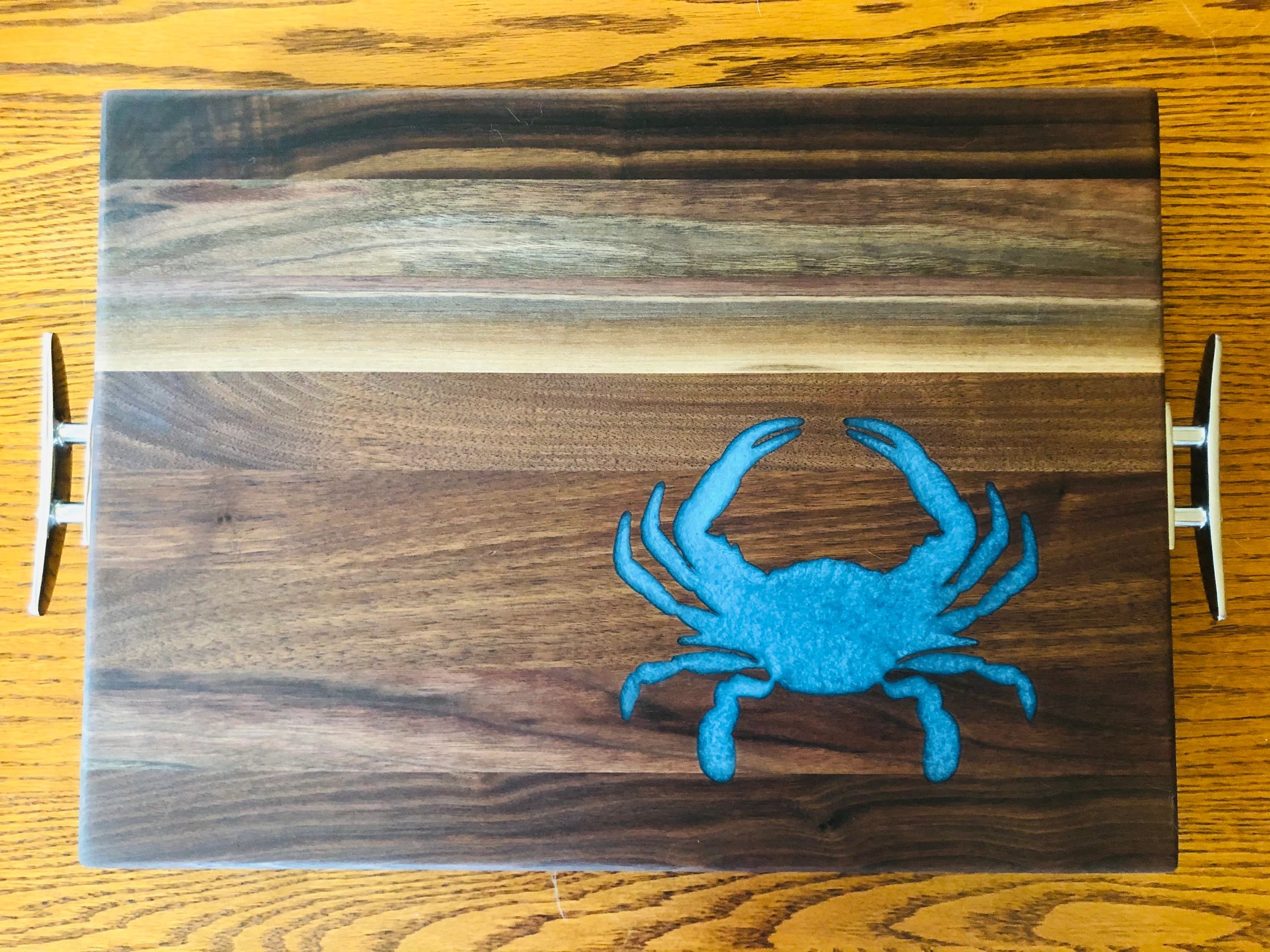 Walnut charcuterie board with inlaid blue crab and dock cleat handles 
