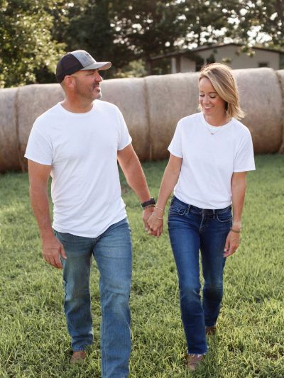 Couple in casual white shirts smiling outdoors.