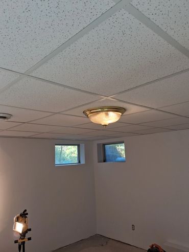 Remodeled basement with finished walls and new drop tile ceiling
