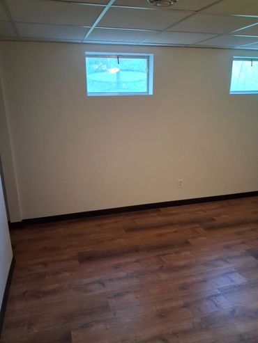 Finished basement remodel with luxury vinyl plank flooring, skip trowel plaster walls, and trim.
