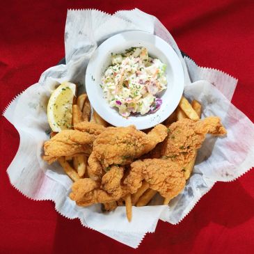Basket of fried chicken strips, fries, and coleslaw.