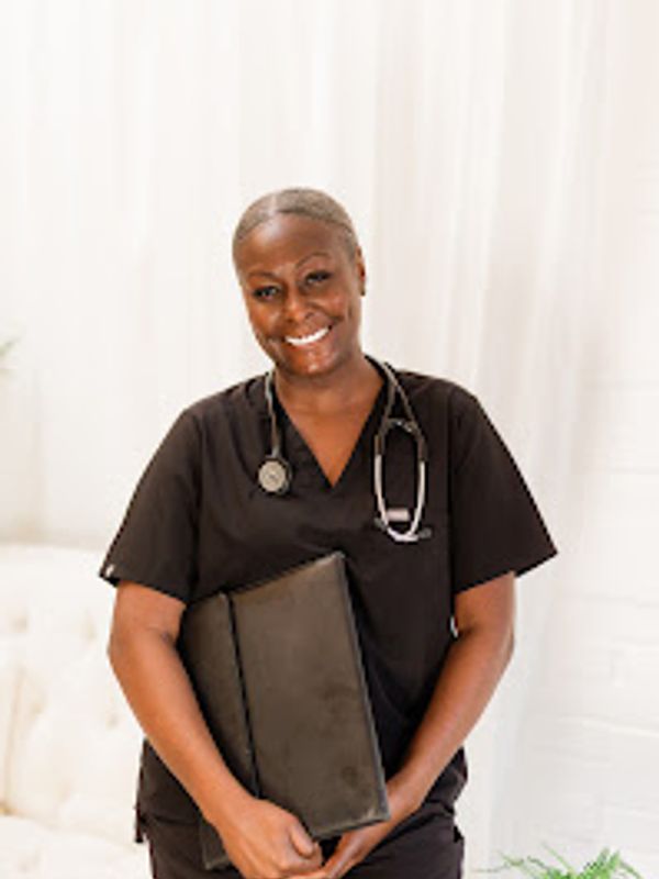 Smiling healthcare professional in black scrubs with a stethoscope and folder.