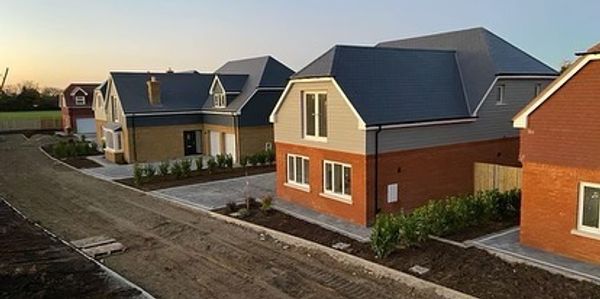 Newly built suburban houses with clean landscaping at sunset.