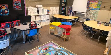 A colorful and organized classroom with various learning stations and tables.
